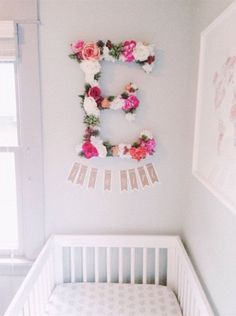 a baby crib with flowers on the wall and an instagramr above it