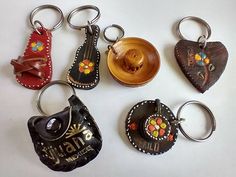 six key chains with different designs on them sitting next to each other in the shape of hearts