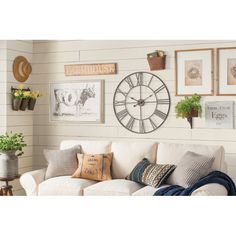 a living room filled with furniture and pictures hanging on the wall above a white couch