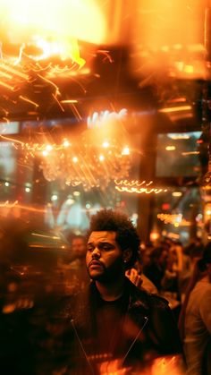 a man standing in front of a fire with his eyes closed and people around him