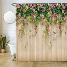 the shower curtain is covered with pink and yellow flowers on a wooden wall next to a bathtub