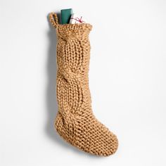 a knitted stocking hanging on the wall with some pens and pencils in it