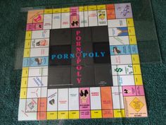 a monopoly board game sitting on top of a green carpet with the words pornoply written in blue