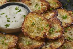 some fried food is on a plate with a small bowl of ranch dressing next to it