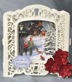 an ornate white frame with red poinsettis and a christmas card on it