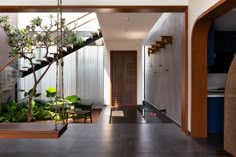 the interior of a modern house with stairs and potted plants on either side of the staircase