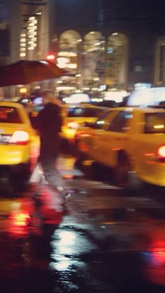 people walking in the rain with umbrellas over their heads and cars parked on the street