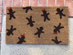 a door mat with black and red teddy bears on it next to a brick wall