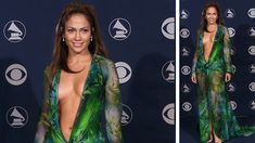 a woman in a green dress standing on a blue carpet and smiling at the camera