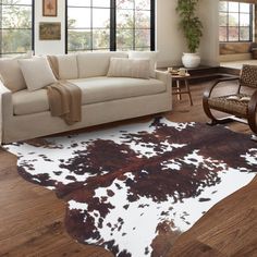 a living room filled with furniture and a cowhide rug