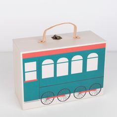 a blue and red box with wheels painted on it's side, sitting on a white surface