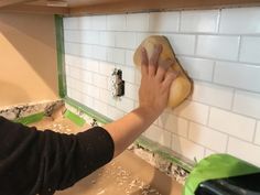 a person wiping up the wall with a sponge