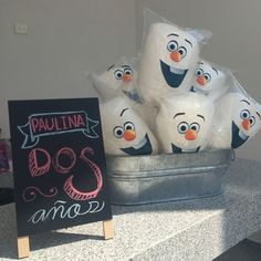 there are some marshmallows sitting in a bucket on the counter next to a sign