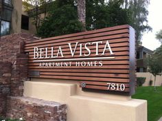 an apartment sign in front of a brick building