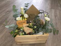 a wooden box filled with wine and flowers on top of a hard wood floored floor