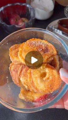 a person holding up a glass bowl filled with doughnuts