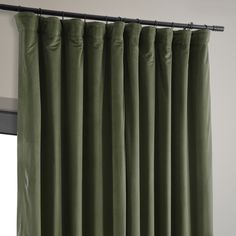 a green curtain hanging on the side of a window