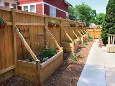 several wooden planters are lined up along the fence