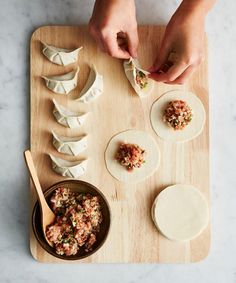 someone is preparing dumplings on a cutting board