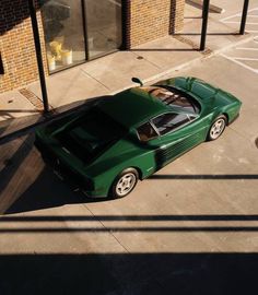 a green sports car parked in front of a building