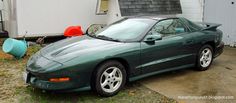 a green sports car parked in front of a house