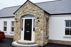 a car is parked in front of a house with a black door and window frame