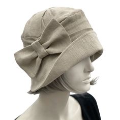 HANDMADE IN THE USAThis cloche from our Alice collection is the quintessential summer hat for all lady-identifying Anglophiles. It makes a great gift for Downton Abbey fans and royal family followers. It’s also a fun treat for yourself if you’re interested in twentieth-century flapper fashion. Lovingly and expertly crafted, this couture cloche hat is made from medium-weight, natural 100 percent linen shown here in beige. Your hat sits deep on the head, which means it offers excellent sun protect Flapper Fashion, Bespoke Hats, Hat With Bow, Hat Handmade, Flapper Style, Cloche Hat, Summer Hat, Handmade Hat, Wedding Hats