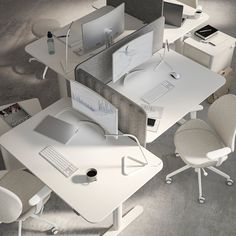 an office cubicle with multiple computers and chairs