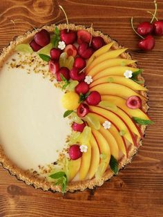 there is a pie with fruit on it and cherries around the edges, along with other toppings