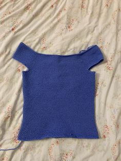 a blue sweater laying on top of a bed