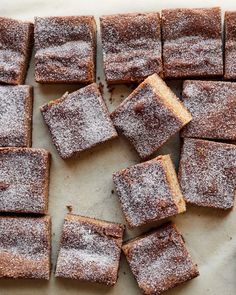 several pieces of cake sitting on top of a cutting board covered in powdered sugar