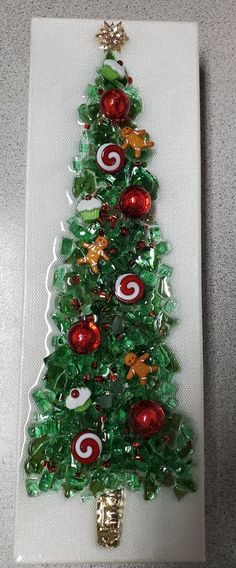 a glass christmas tree with red and green ornaments