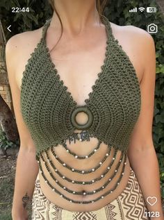 a woman wearing a green crochet halter top with beads on the bottom