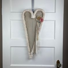 a white door with a heart shaped decoration hanging on it