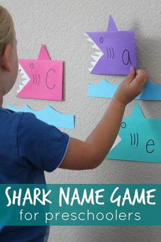 a young boy is making shark name game for preschoolers