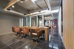 an empty room with chairs and desks in the center, is lit by recessed lights