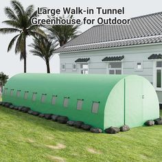 large walk - in tunnel greenhouse for outdoor play area on grass with palm trees