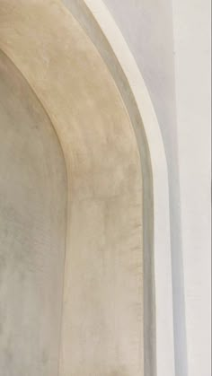 a cat is sitting on the ledge of a white wall and looking at something off in the distance