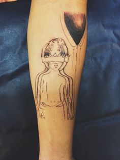 a person with a tattoo on their leg that has an image of a woman holding a balloon