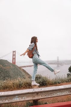 a woman is walking along the side of a road with her hand in the air