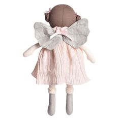 a stuffed animal with a pink dress and bow on it's head, sitting in front of a white background