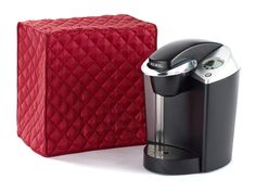 a coffee maker next to a red quilted box on a white background with clippings