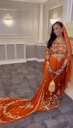 a woman in an orange and gold wedding dress