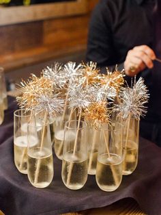 several glasses filled with champagne and gold sprinkles on top of a table