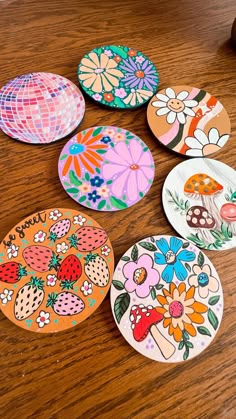 six colorful plates sitting on top of a wooden table