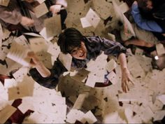 a group of people standing on top of a floor covered in papers and paper machs