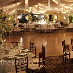 a banquet hall with tables, chairs and lights