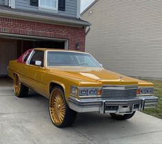 a yellow car parked in front of a garage