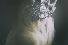 a woman with white hair and a crown on her head is wearing a veiled dress