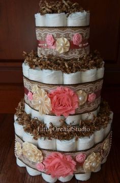 a three tiered diaper cake with pink flowers on it